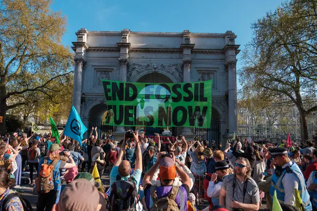 Manifestantes ambientalistas protestan levantan una pancarta contra los combustibles f&oacute;siles en Londres | Foto: Ehimetalor Akhere Unuabona, Unsplash