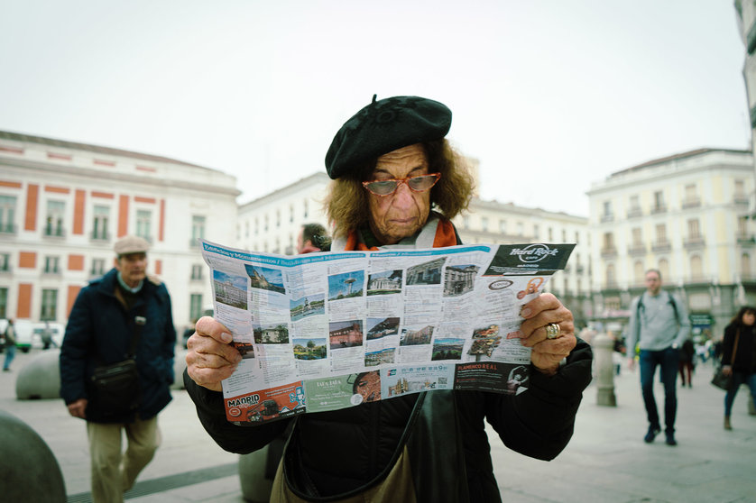 Una mujer lee un folleto en la madrileña Plaza del Sol | Sergio Moreno López
