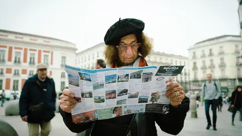 Una mujer lee un folleto en la madrile&ntilde;a Plaza del Sol | Sergio Moreno L&oacute;pez