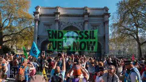 Manifestantes ambientalistas protestan levantan una pancarta contra los combustibles f&oacute;siles en Londres | Foto: Ehimetalor Akhere Unuabona, Unsplash