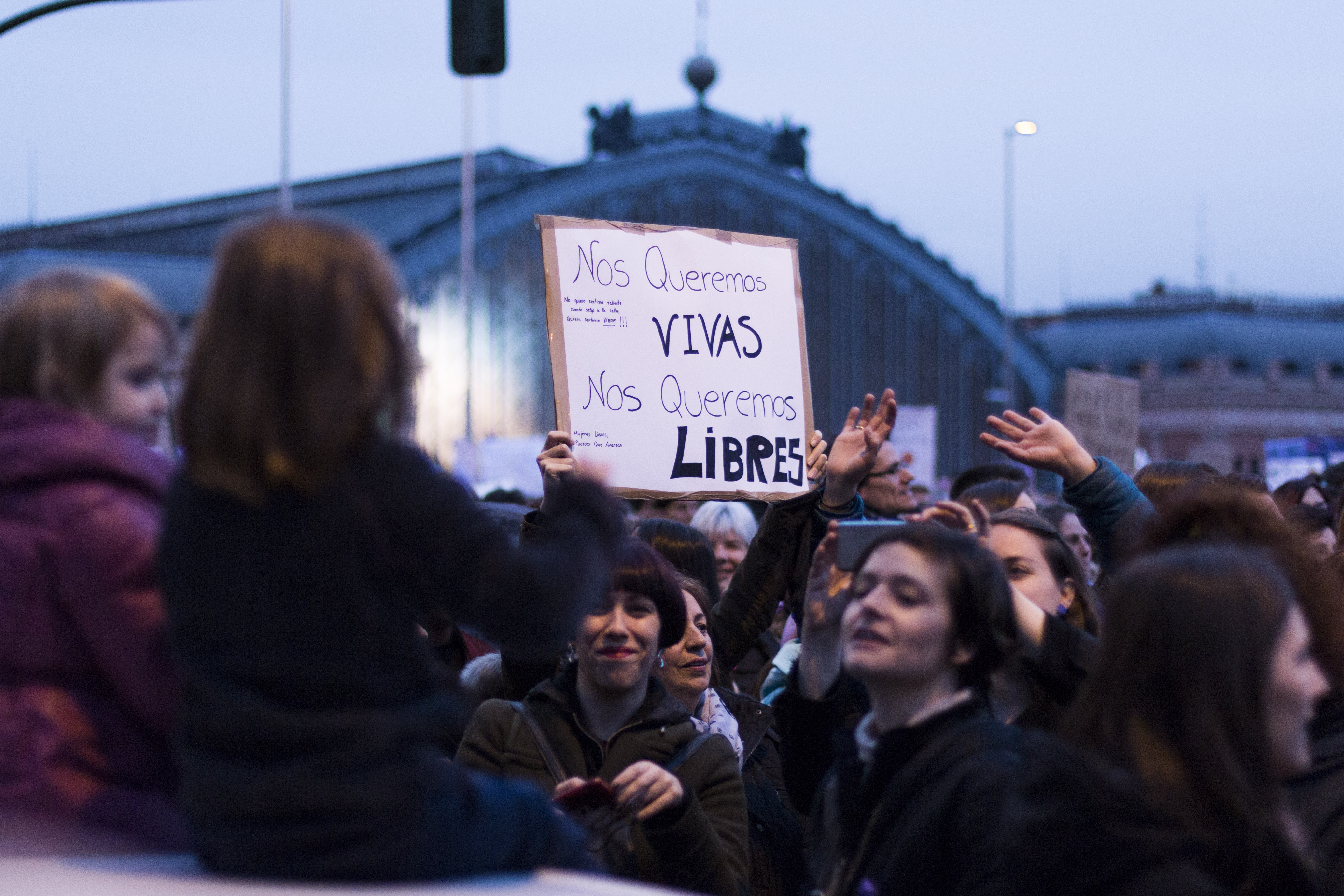 Una mujer alza una pancarta en la que se lee 