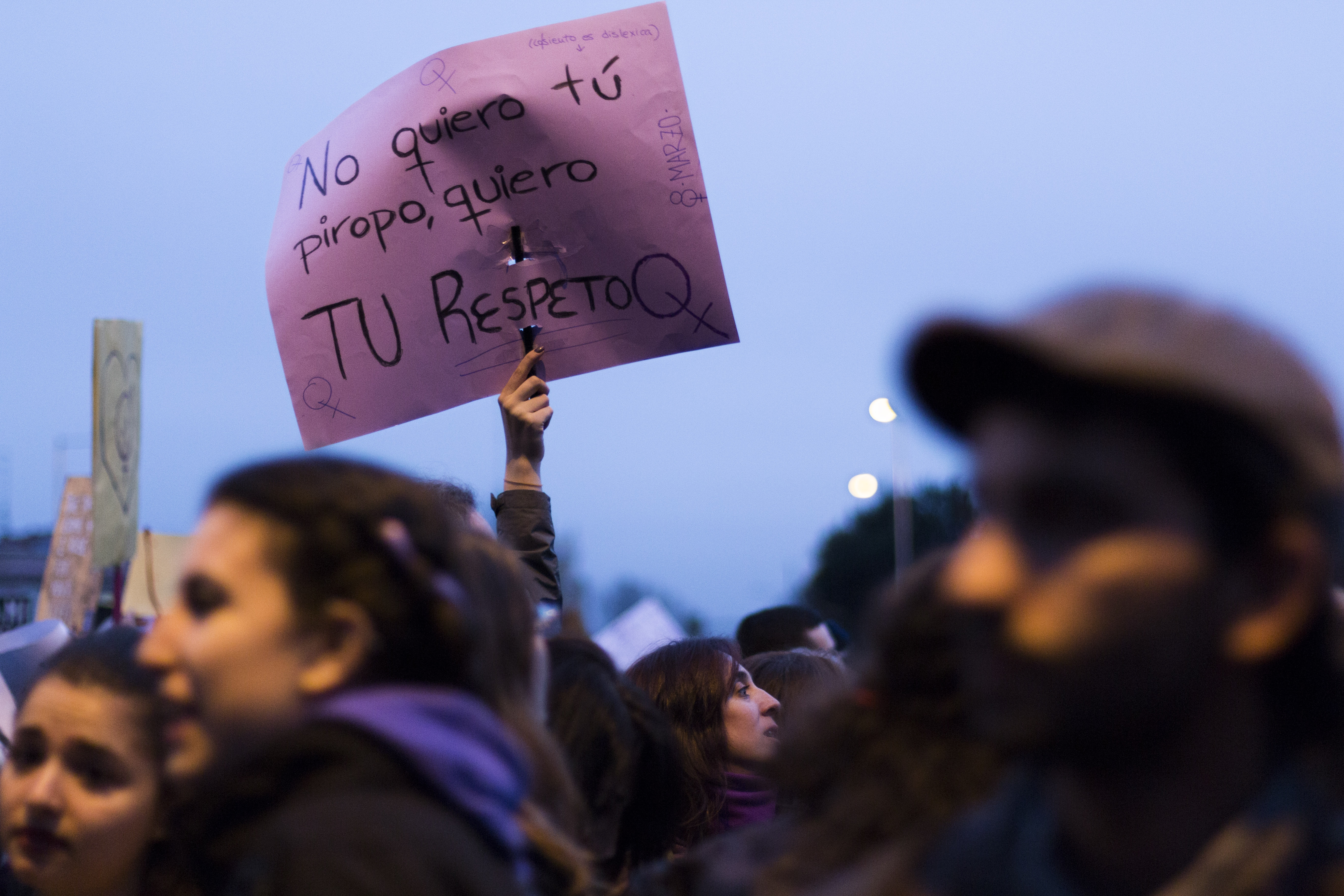 Una mujer alza una panzarta en la que se lee 